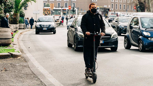 Man riding electric scooter on city street wearing mask to get a full experience with scooter steps