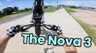 Person holding a drone with 'The Nova 3' text on a road.