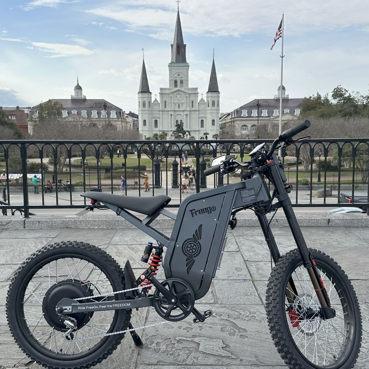 Electric bike with 'Frungio' branding in front of a cityscape with a prominent building.