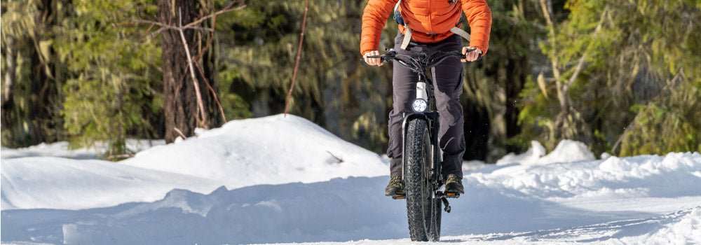 Fat Tire electric bike riding on snowy trail for hunting with wide tires and stable terrain handling