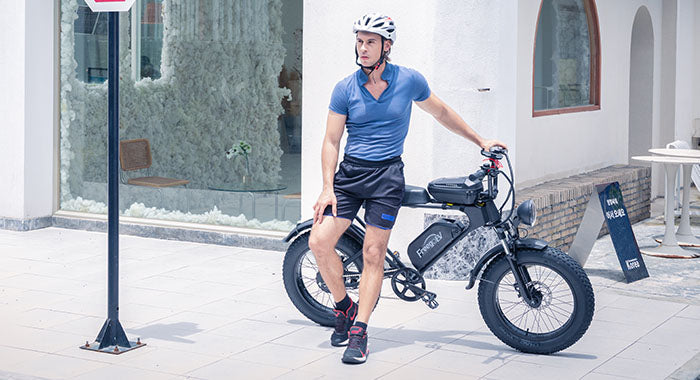 A sporty man leaning on the black Freego DK200 at the corner of the street