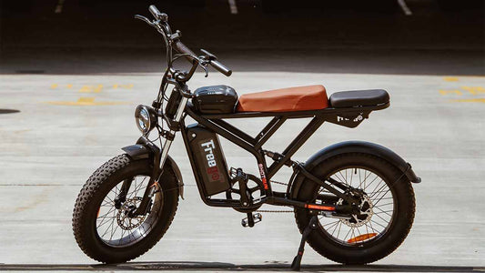 black electric bicycle with brown seat parked on concrete floor in outdoor setting