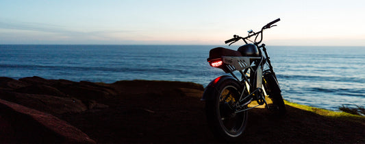 A Freego F3 parked in front of a vast sea in the beginning of sunset