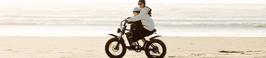 Mother and child riding a high-quality Freego electric bicycle on the beach, highlighting commitment against low-quality imitations