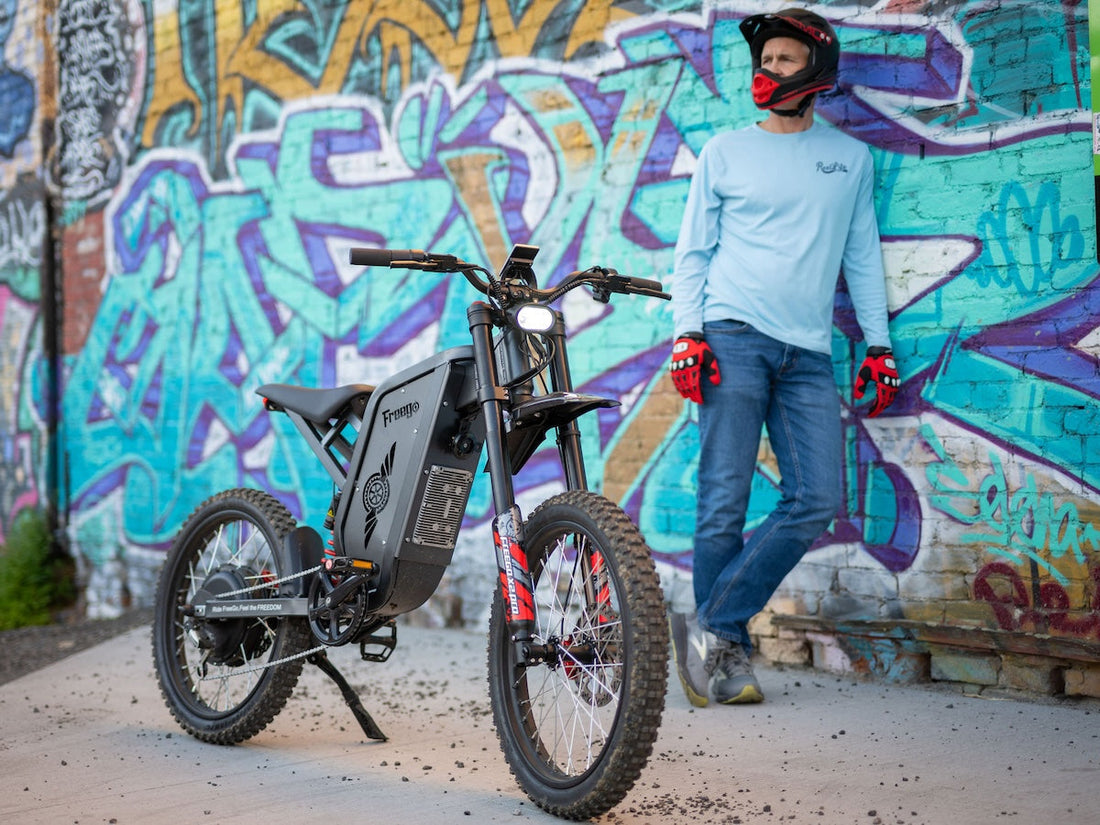 A rider with a helmet stands next to a black Freego X2 Pro, showcasing the sleek frame housing the powerful smart controller.