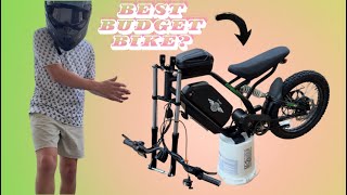 A presenter next to a compact electric bike and its disassembled components