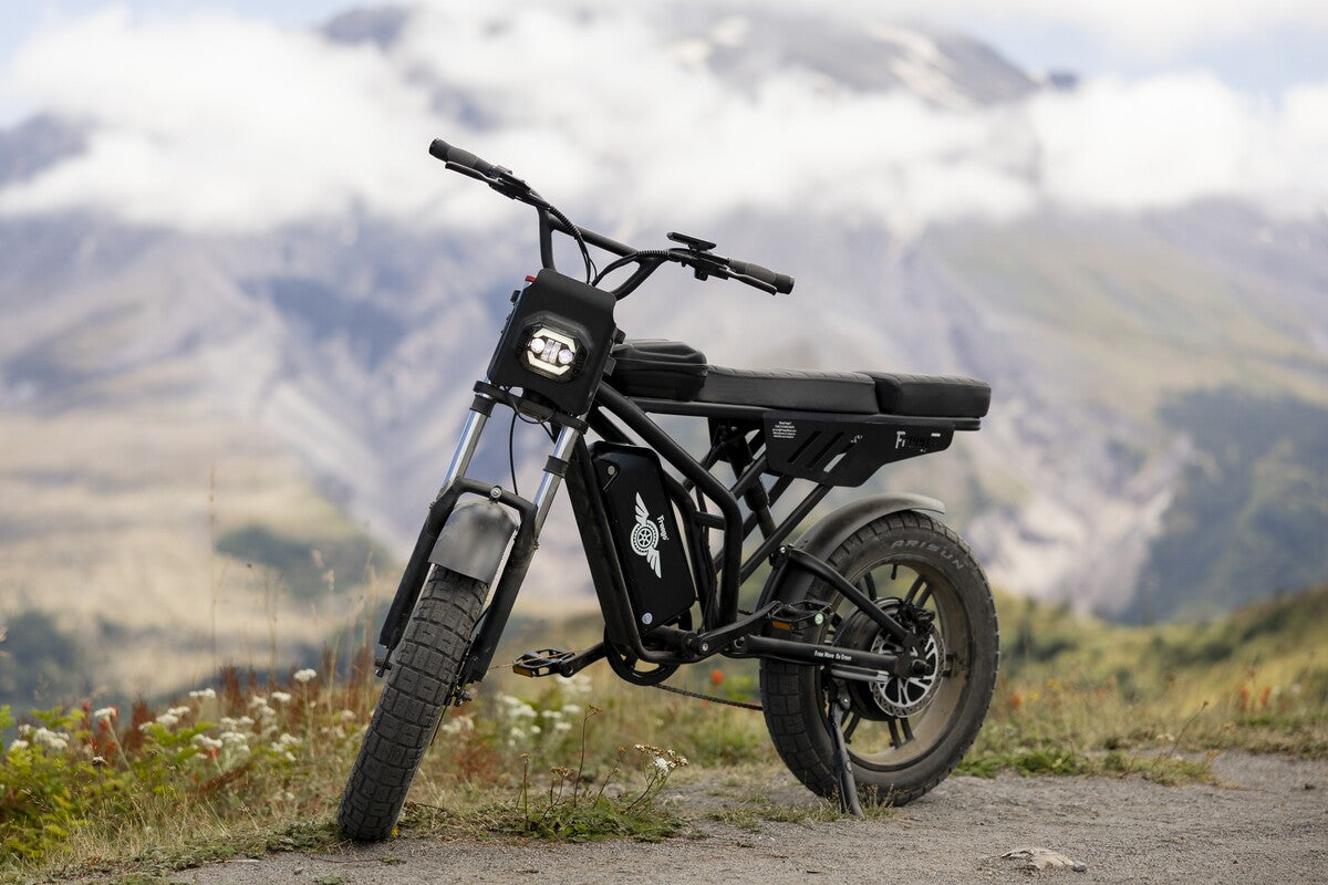 Freego-F2-pro-max: Black electric bike on a mountain road with mountains in the background