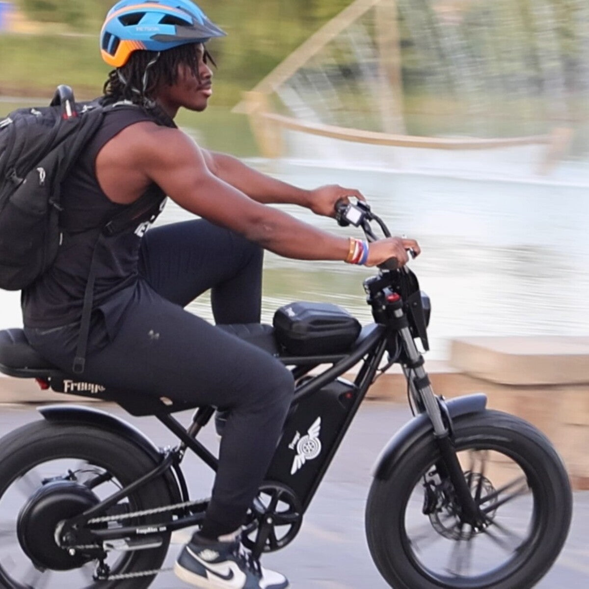 Person riding a black electric bike on a blurred background