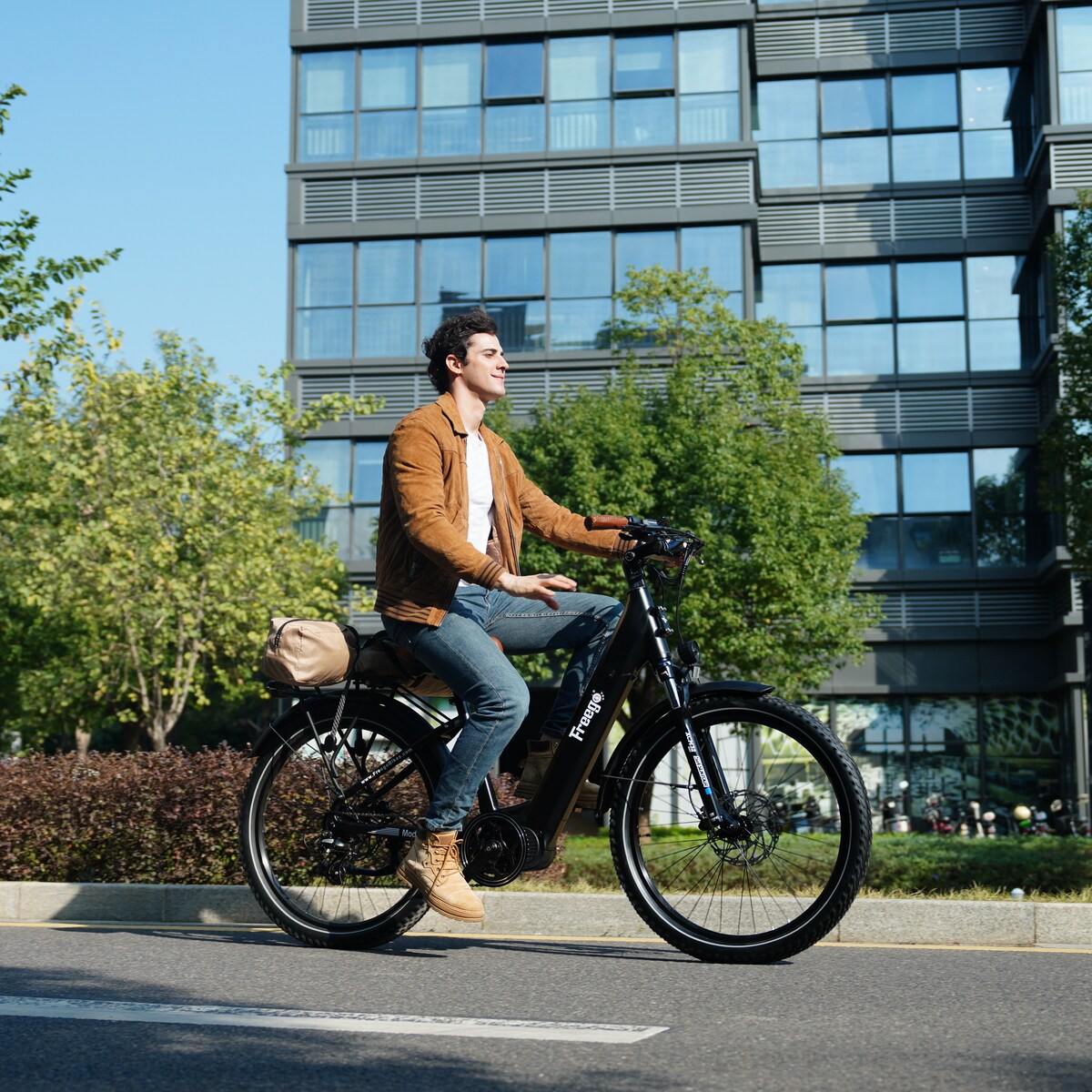 Man riding freego A1 on a city street with modern buildings in the background