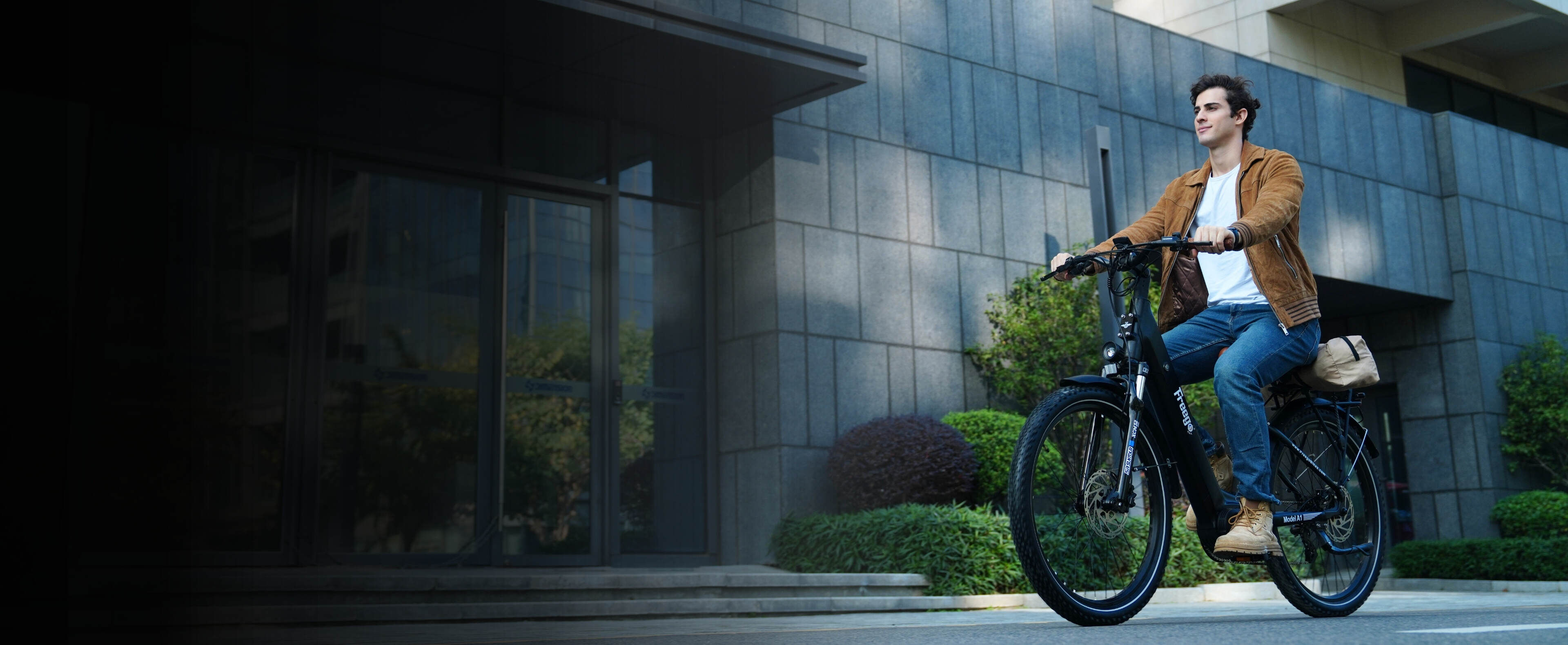 A man rides freego A1 through a modern urban setting, carrying a small bag.