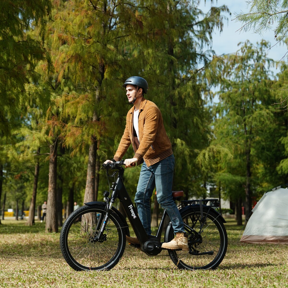 Man riding freego A1 in a park with trees and grass in the background