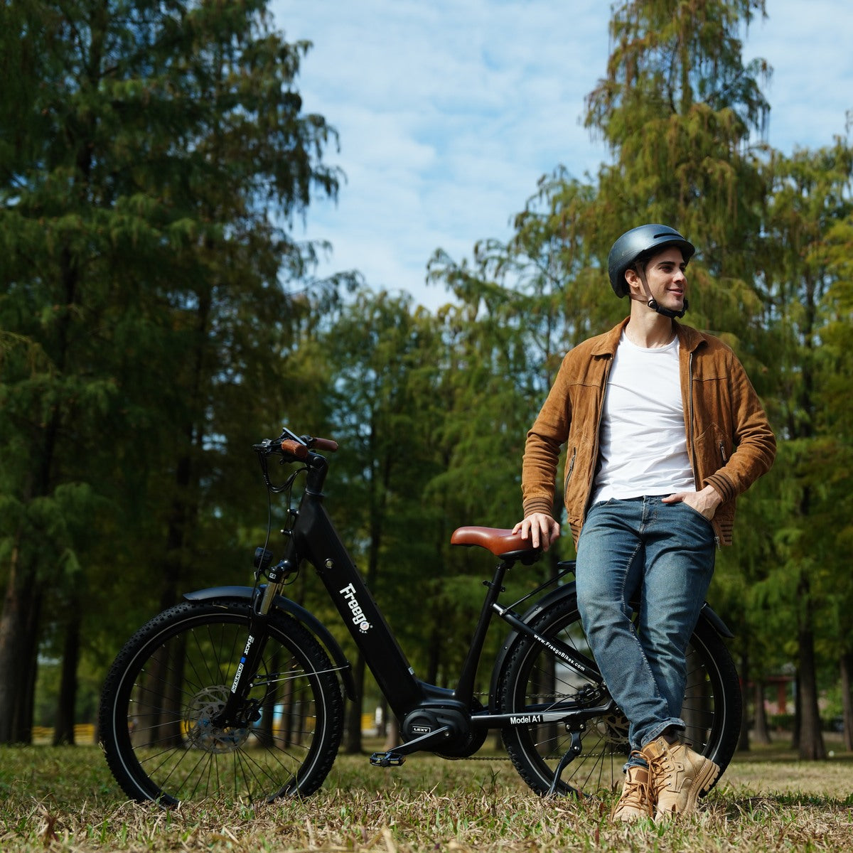 Man standing next to freego A1 in a park with trees and blue sky in the background