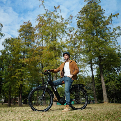 Man standing with Freego City Flow A1 Electric Bike in a park with trees and blue sky.