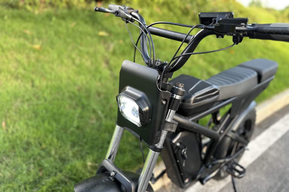 Close-up of Freego F2 Pro Max headlight and handlebar, with seat and frame partially visible.