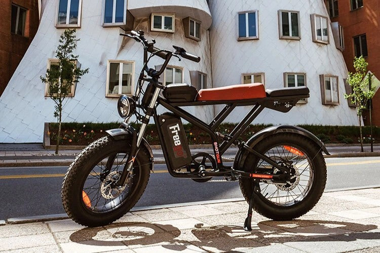Electric bike parked on a sidewalk with a modern building in the background