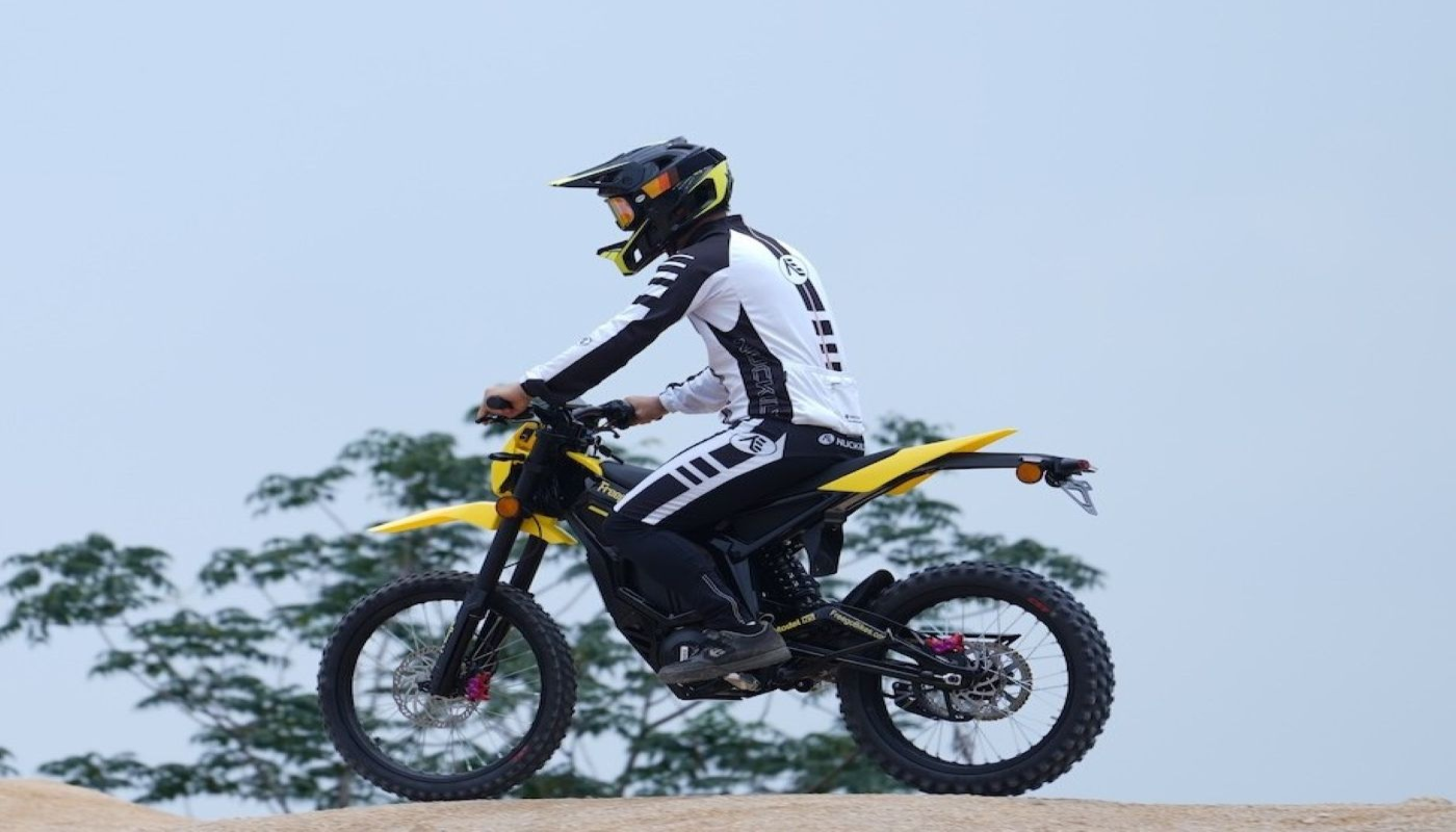 Person riding a dirt bike with a helmet on a clear day
