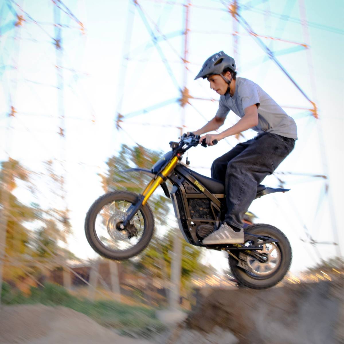 Rider jumping the Freego Nova 5 Mini over a dirt mound during an off-road ride.