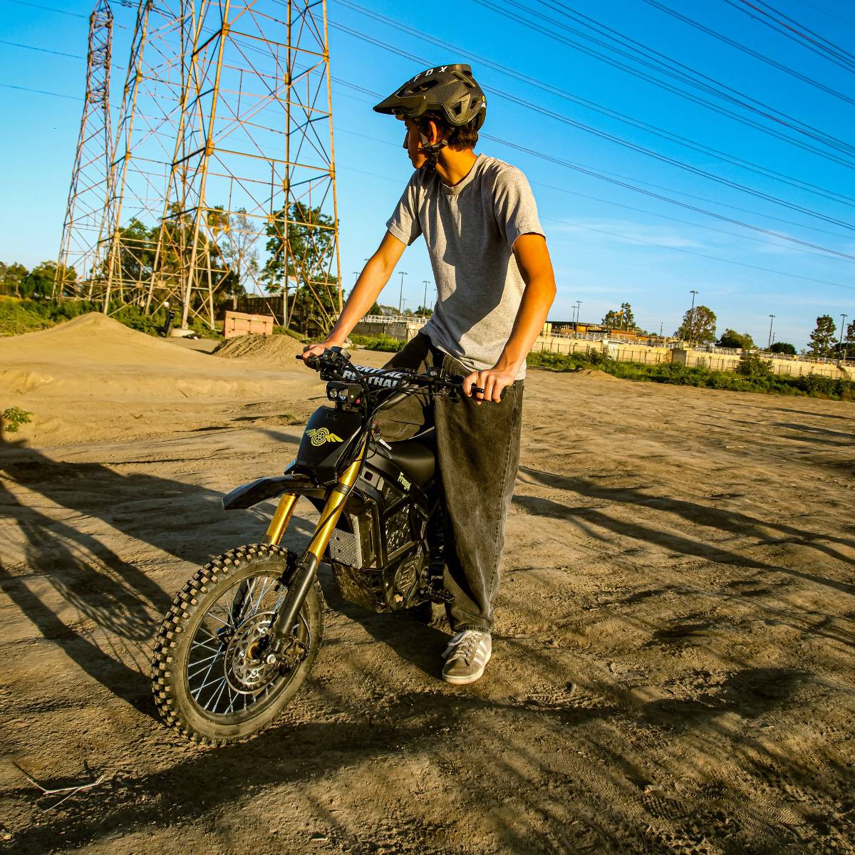 Rider standing with the Freego Nova 5 Mini on a dirt trail during an off-road ride.