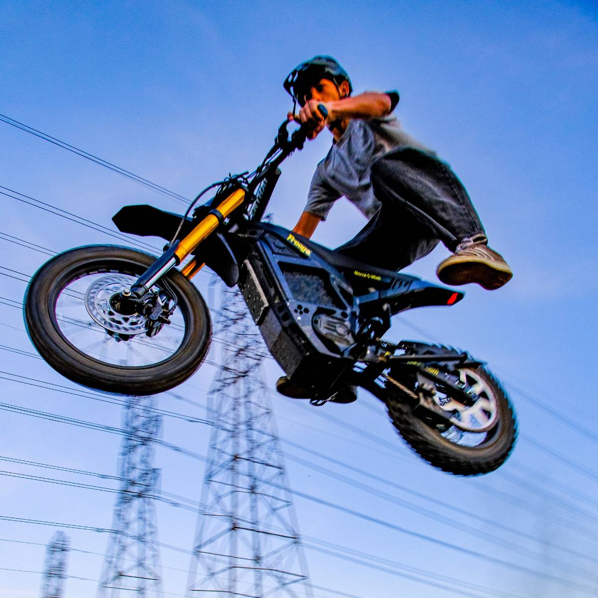 Front side view of a rider performing a high jump on the Freego Nova 5 Mini during an off-road ride.