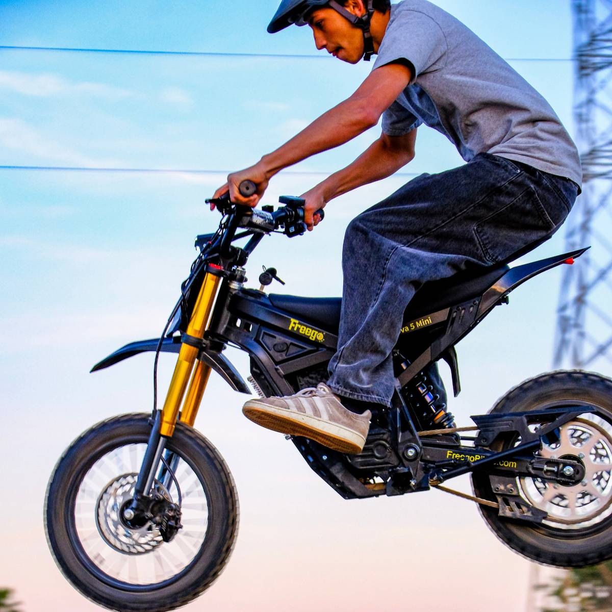 Close view of a rider in mid air on the Freego Nova 5 Mini during an off-road jump.