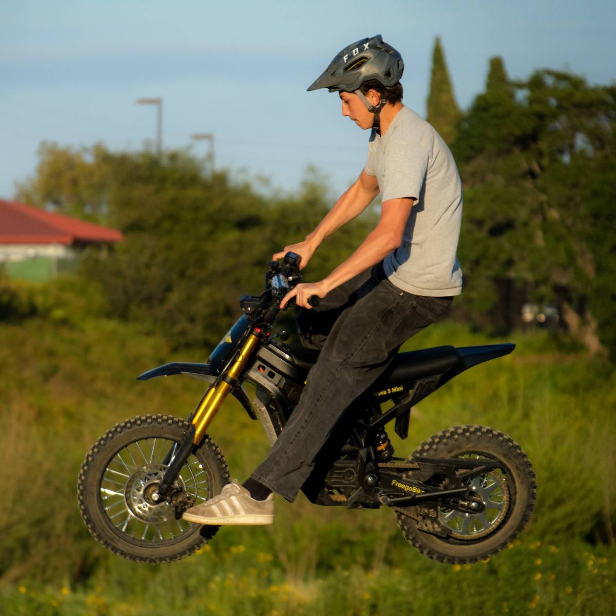 Rider riding the Freego Nova 5 Mini on a grassy off-road trail, showing its lightweight design and smooth all-terrain handling.