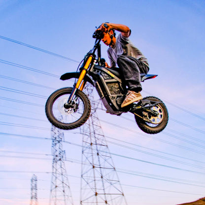Rider performing a high jump on the Freego Nova 5 Mini during an off-road ride with open sky in the background.