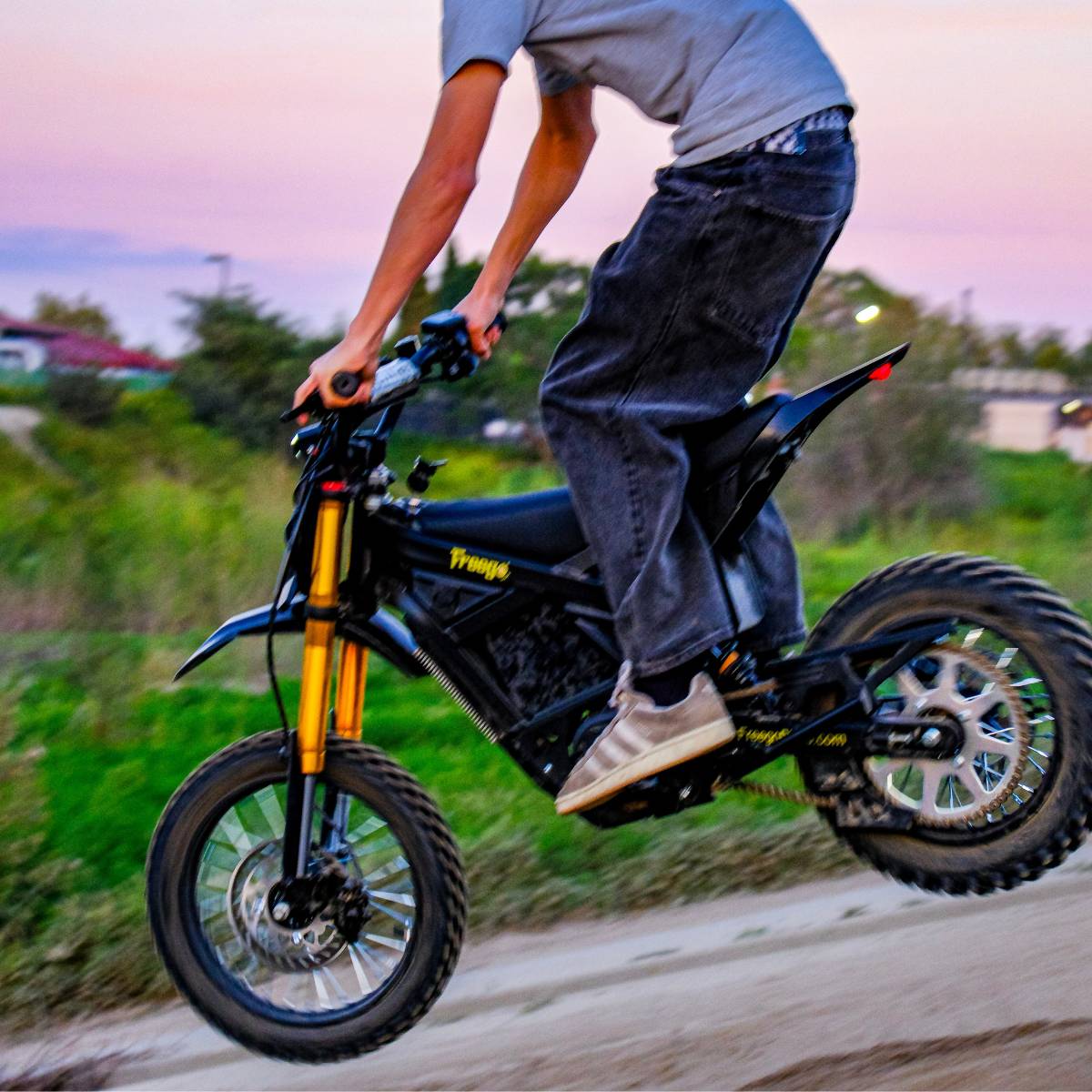 Rider landing while riding the Freego Nova 5 Mini on an off-road trail.