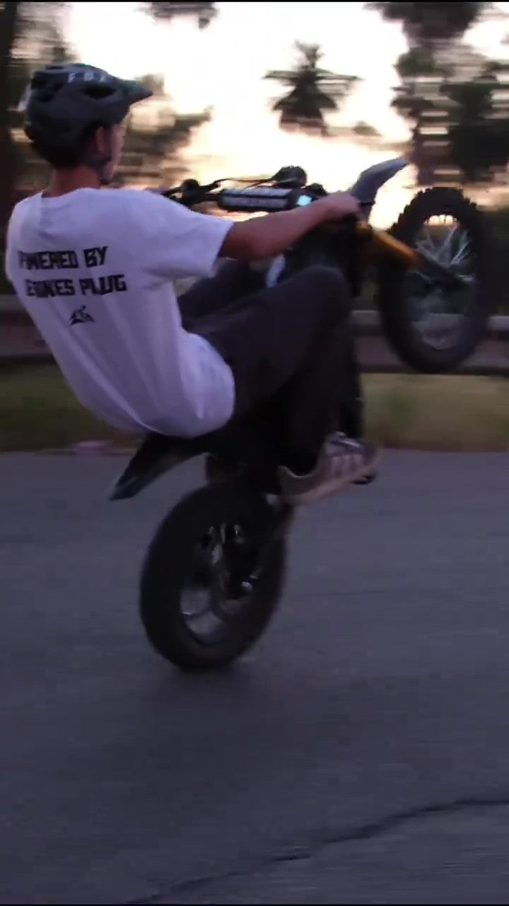Person performing a wheelie on a freego nova 5 mini with a sunset background