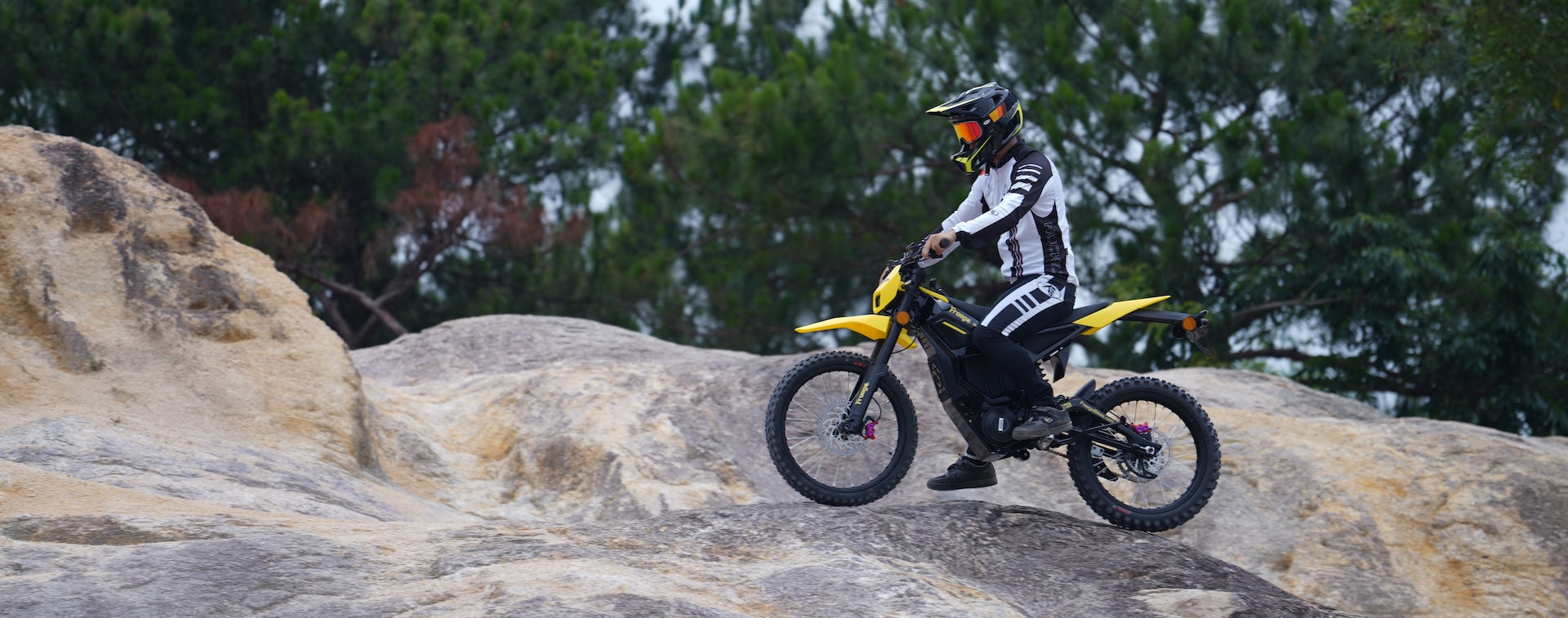 Rider on a Freego Nova 5 electric dirt bike navigating rocky terrain.