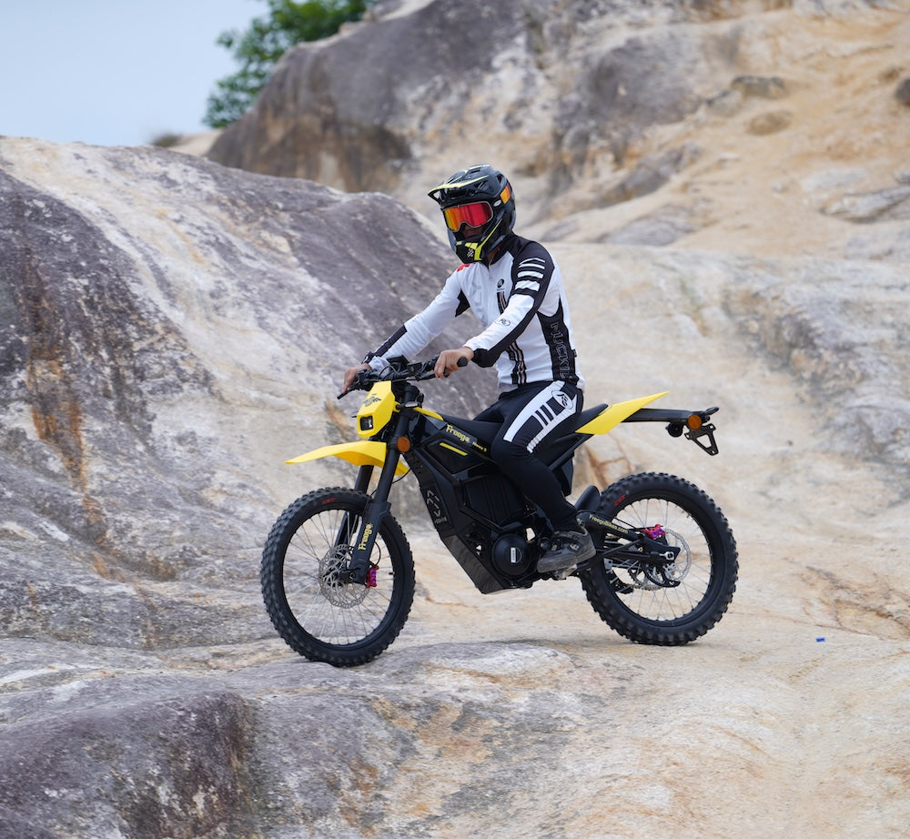 Rider on a Freego Nova 5 e-bike navigating rocky terrain in full gear.