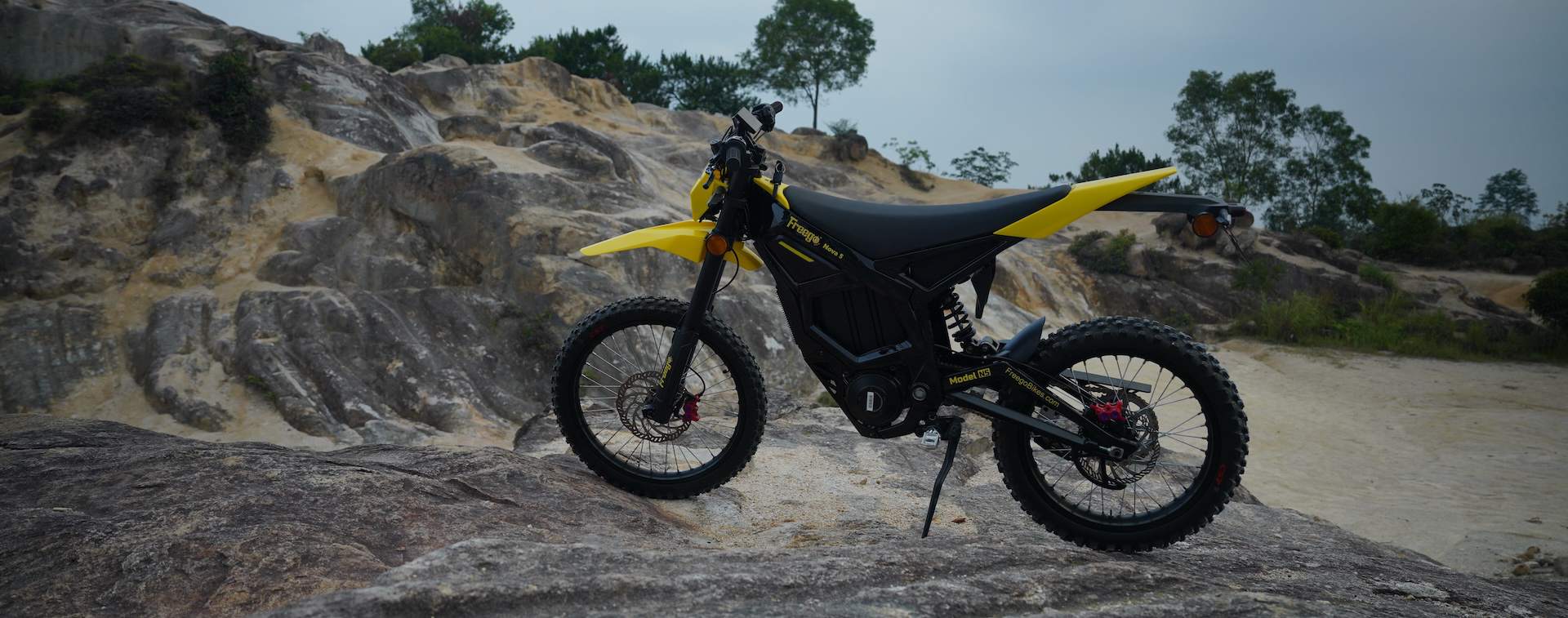 Freego Nova 5 electric dirt bike on rocky terrain.