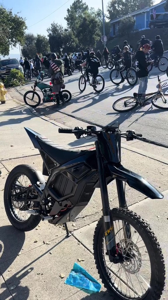 Freego Nova 5 on a sidewalk with people and bicycles in the background