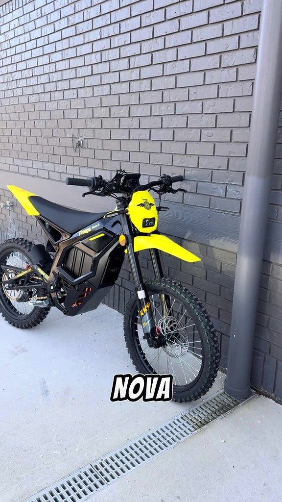 Freego_Nova_5 Yellow electric bike labeled 'NOVA' against a gray brick wall.