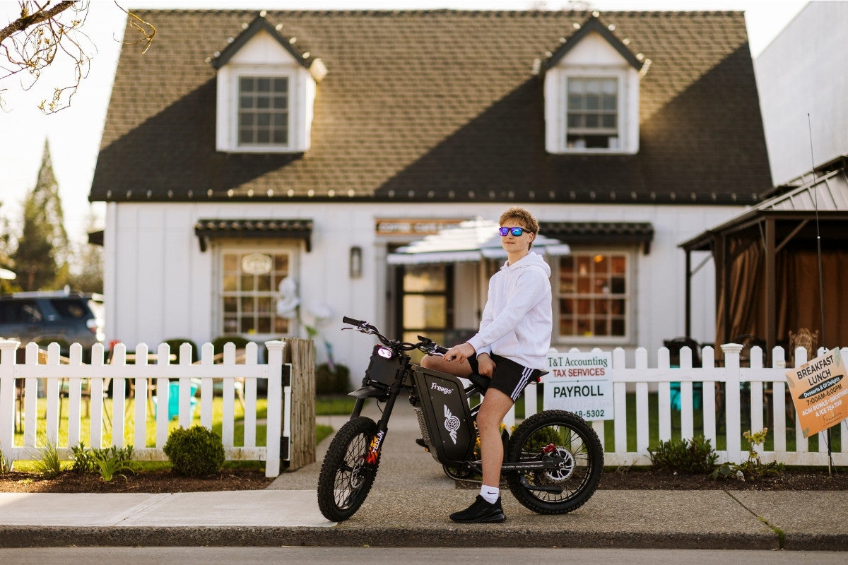 Person sitting on a freego x1 in front of a house with a white picket fence.