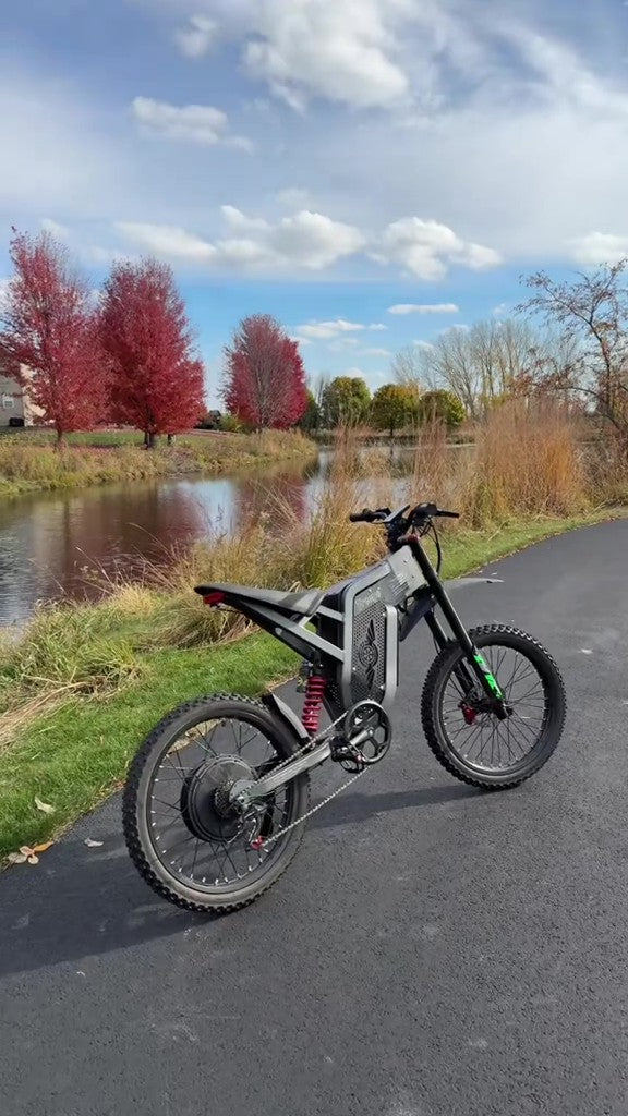 Freego X2 Electric bike on a paved path with trees and a pond in the background