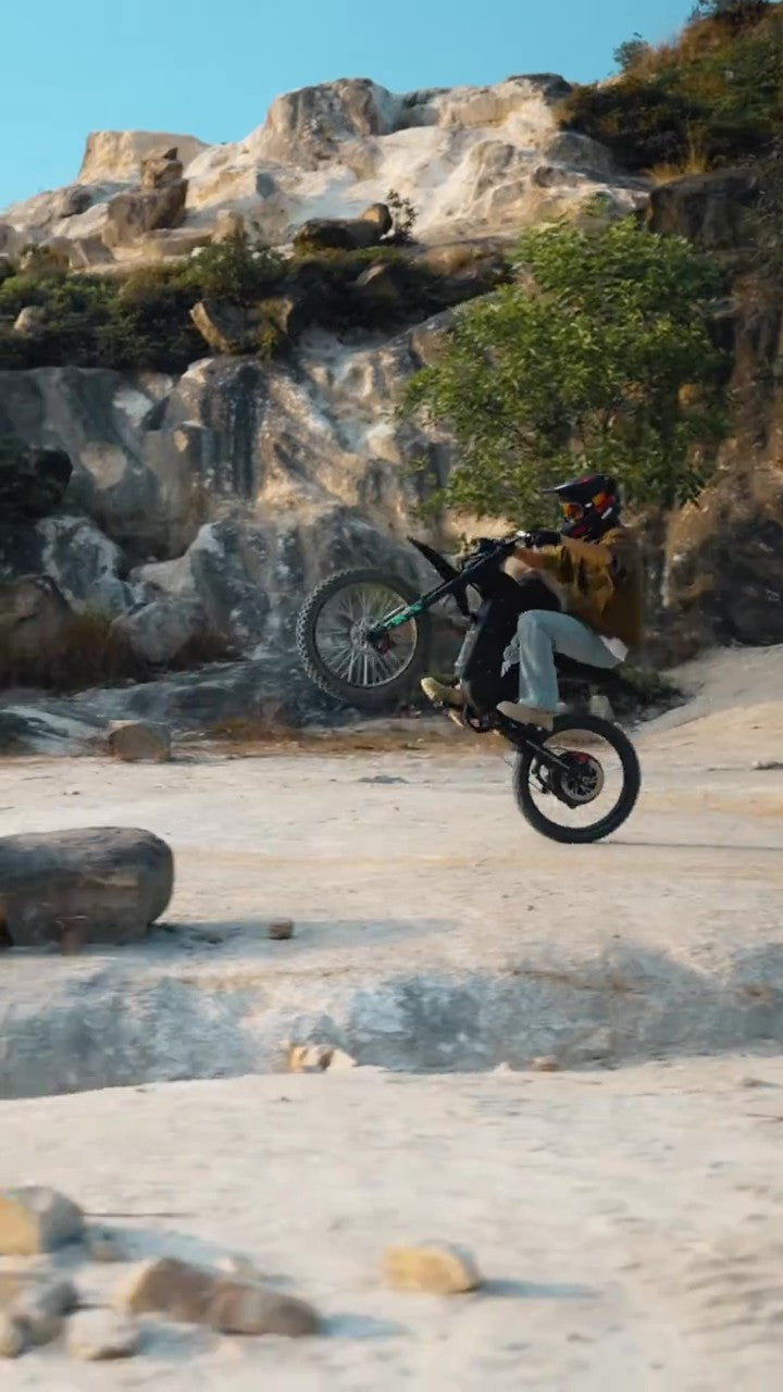 Person riding a freego x3 on a rocky terrain with ancient ruins in the background