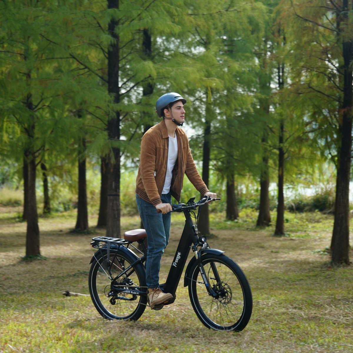 Man riding an Freego City Flow A1 Electric Bike in a park with trees in the background