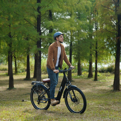 Man riding an Freego City Flow A1 Electric Bike in a park with trees in the background