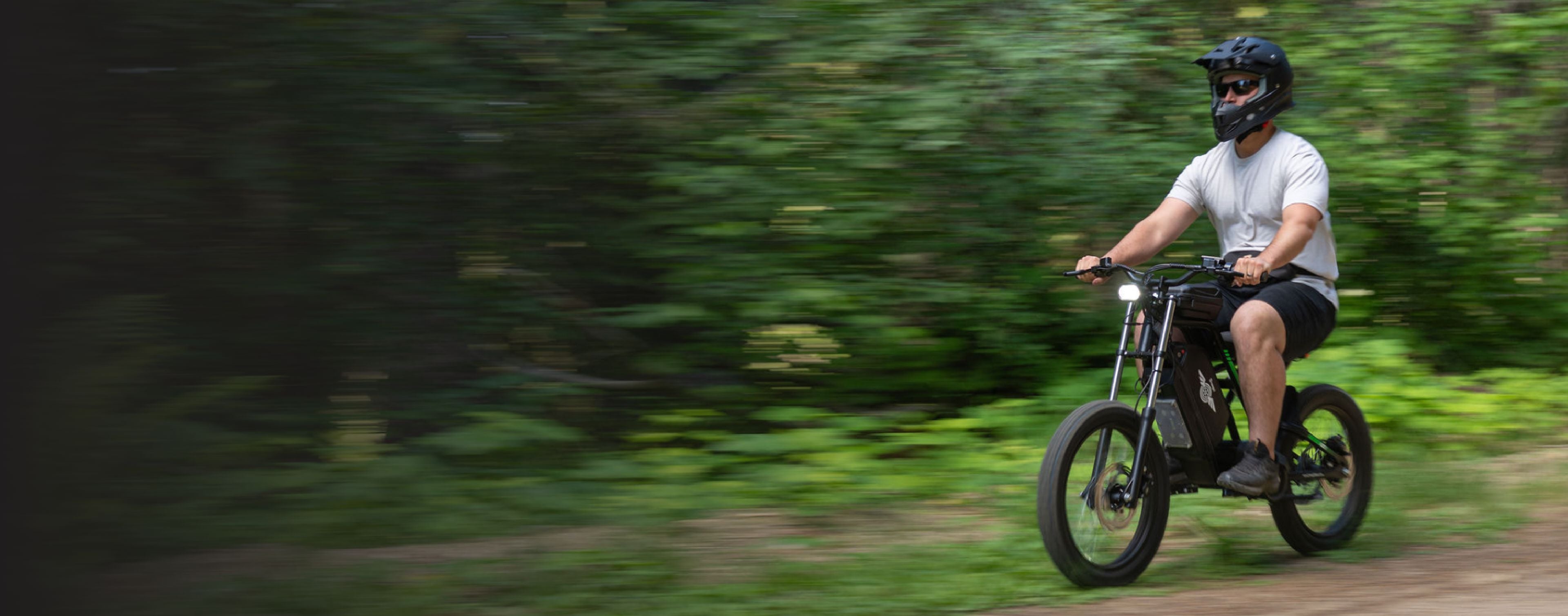 A man riding the Nova 3 e-bike outdoors, with a motion-blurred background.