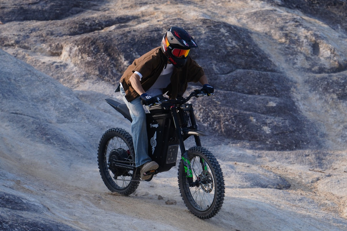 Person riding a Freego X3 electric bike on rocky terrain