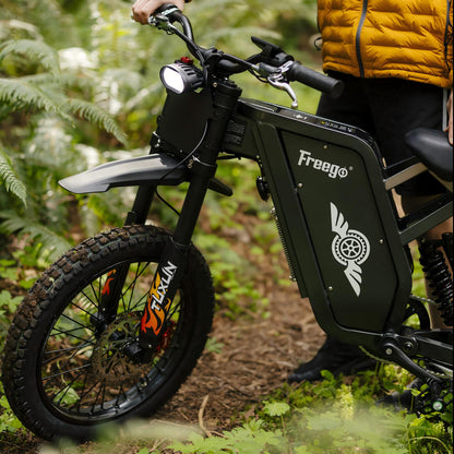 Close-up view of a Freego X1 SE featuring fat tires, front suspension, and rugged off-road design on a forest trail.