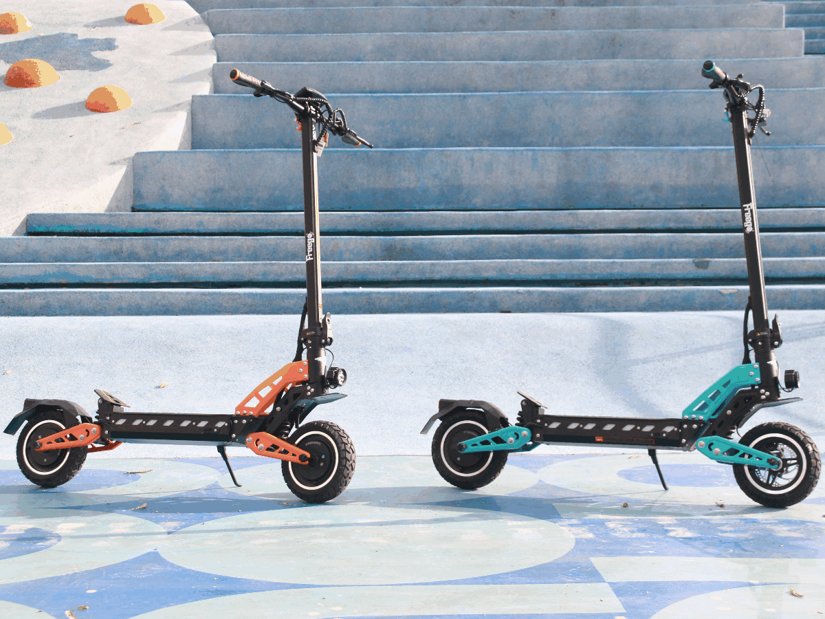 Two electric scooters, one black and orange, the other black and teal, on a blue and white patterned surface.