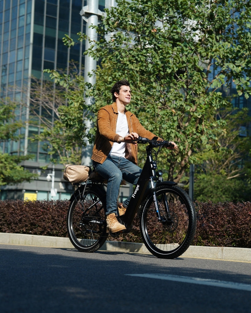 A rider commuting on a black Freego A1 city electric bike on an urban road.