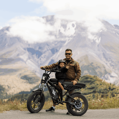 Man and child on a motorcycle with mountains in the background