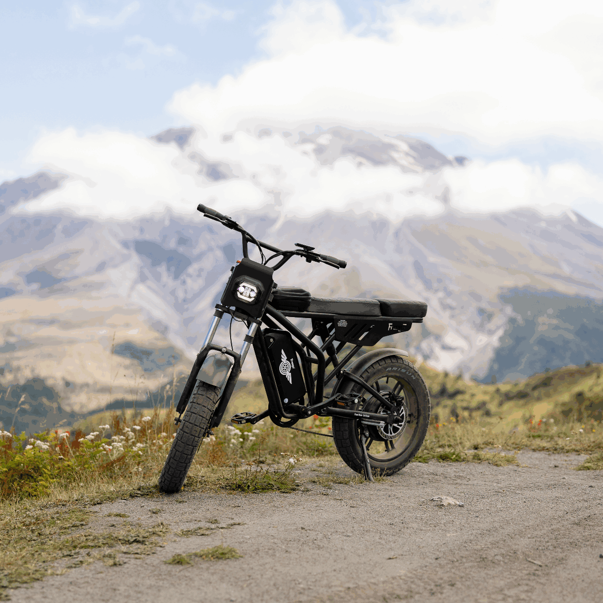 Black electric bike on a dirt path with mountains in the background