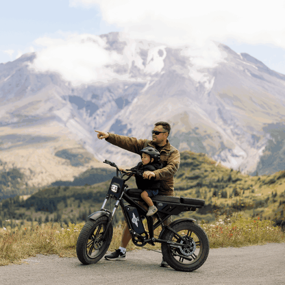 Man and child on a motorcycle with mountains in the background