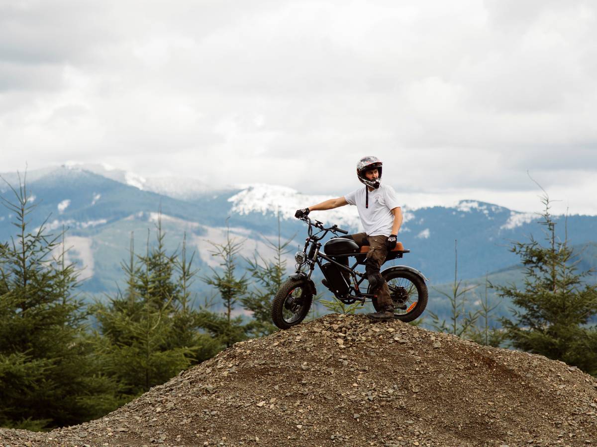 Rider on the Freego F3 Pro electric dirt bike riding on a mountain trail.
