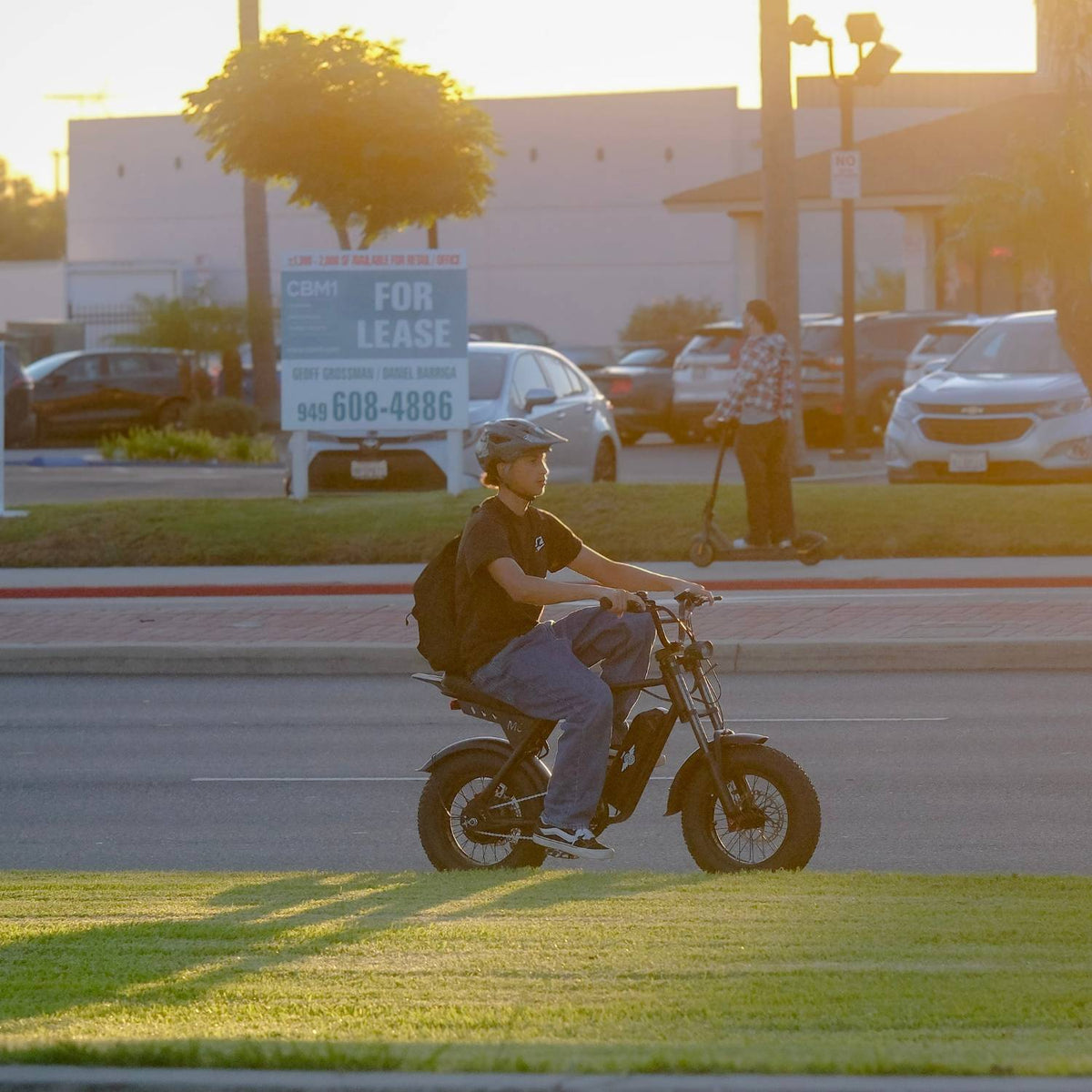 Rider cruising a Freego M3 electric mini bike along a city street in warm evening light.