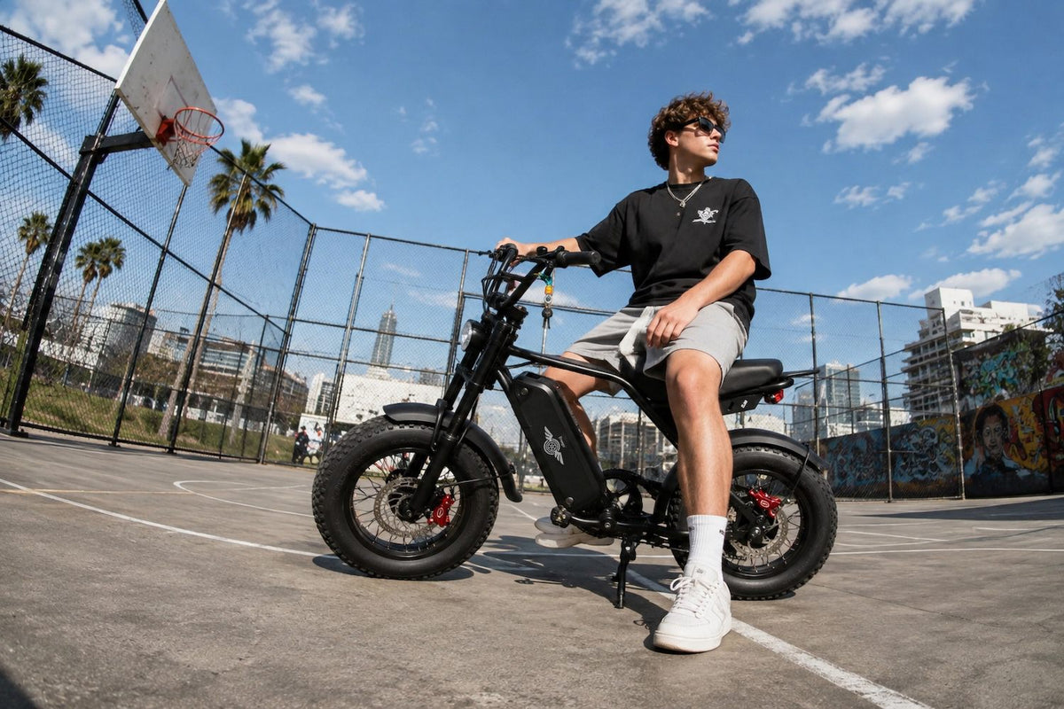 Young rider sitting on a Freego M3 fat tire e-bike at an outdoor basketball court