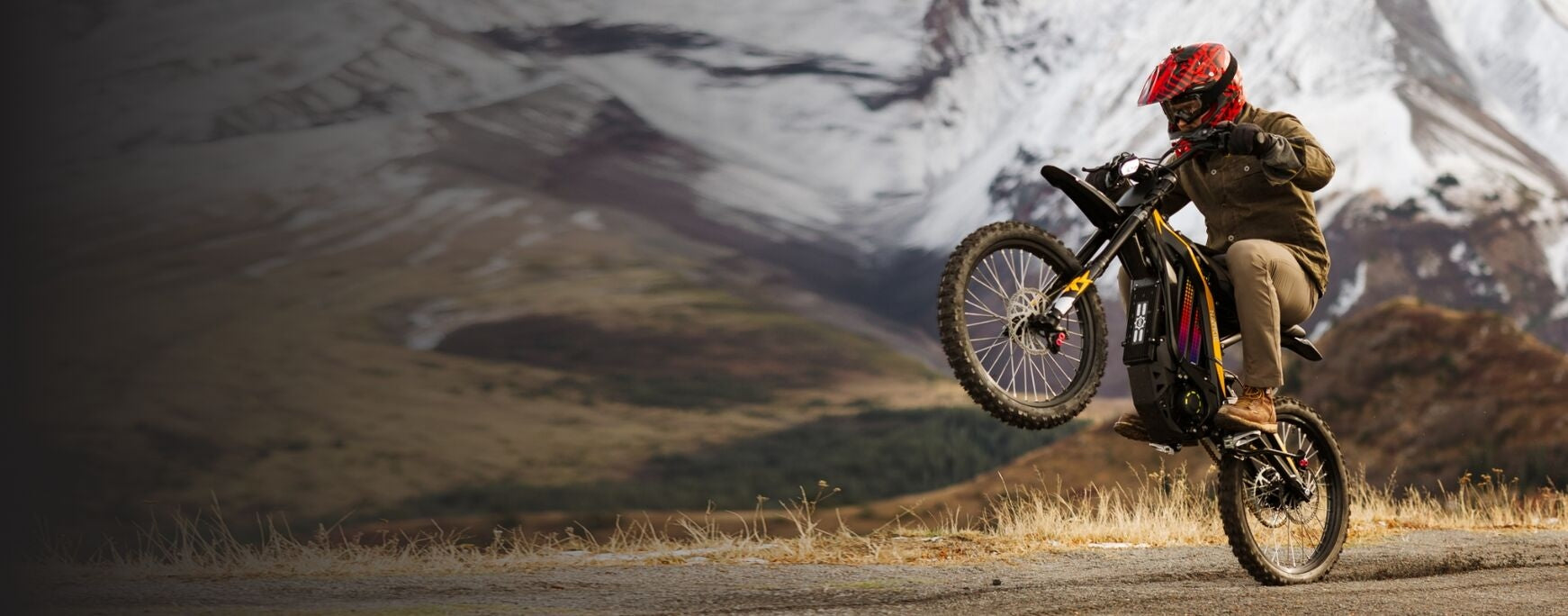 Person riding a Freego N1 on a dirt road with mountains in the background